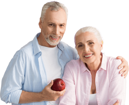 A man and woman holding an apple in front of them.