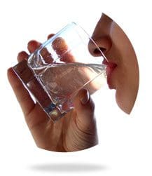 A person holding a glass of water in their hand.